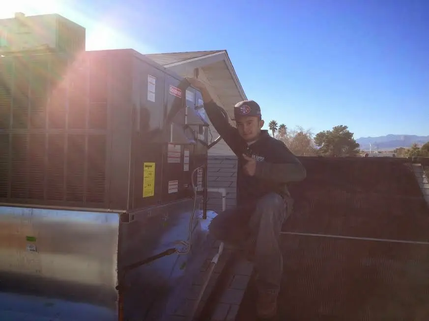HVAC technician performing Heat Pump Repair on a rooftop unit in Renton